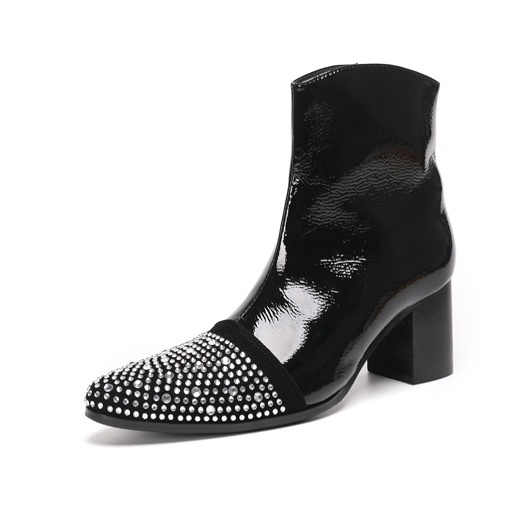 A pair of black patent leather ankle boots with rhinestone-embellished pointed toes and block heels.