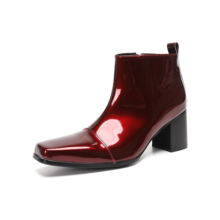 A pair of shiny burgundy patent leather ankle boots with a square toe and block heel, featuring a side zipper closure.