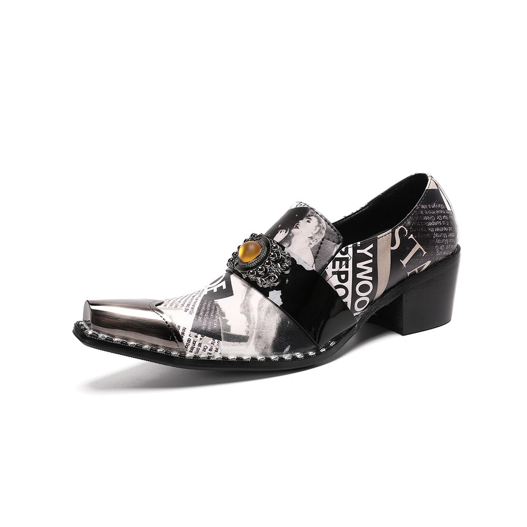 Pair of men's black and white newspaper print slip-on dress shoes with pointed silver metal toe caps and decorative buckles.