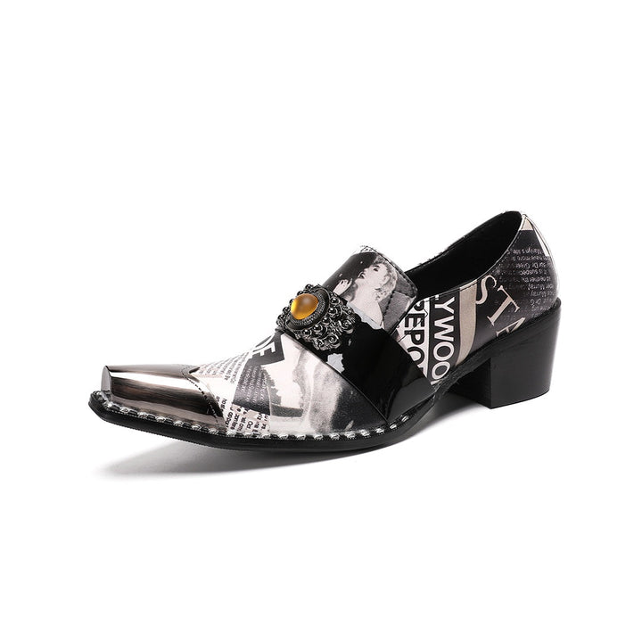 Pair of men's black and white newspaper print slip-on dress shoes with pointed silver metal toe caps and decorative buckles.