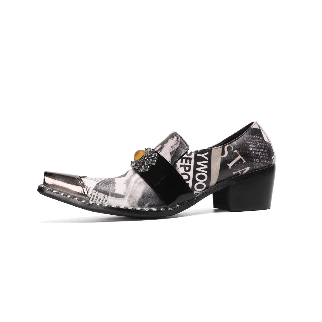 Pair of men's black and white newspaper print slip-on dress shoes with pointed silver metal toe caps and decorative buckles.