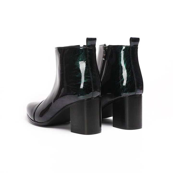 Pair of iridescent dark green patent leather pointed toe ankle boots with block heels and side zippers.