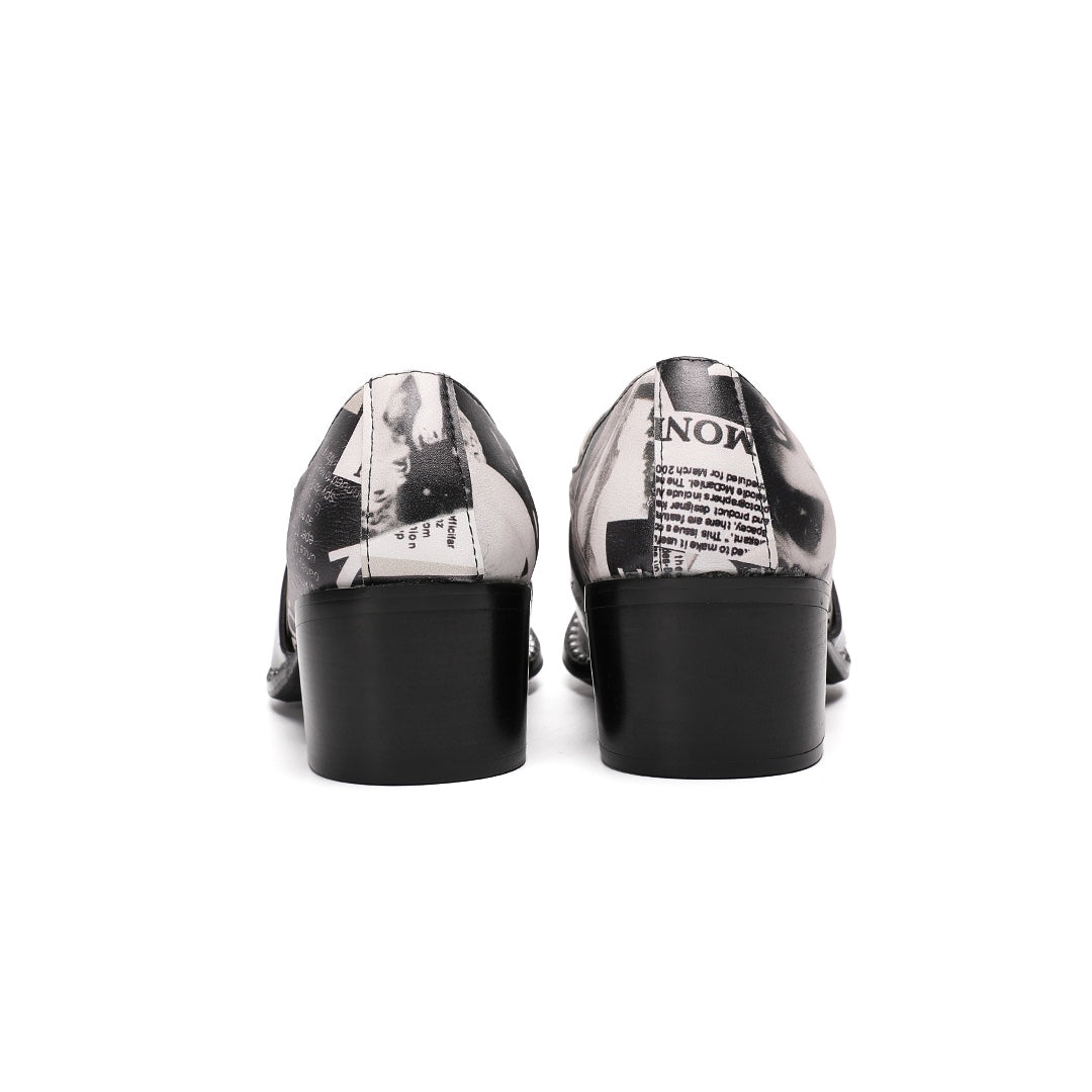 Pair of men's black and white newspaper print slip-on dress shoes with pointed silver metal toe caps and decorative buckles.