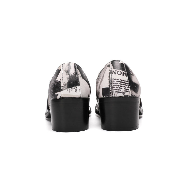 Pair of men's black and white newspaper print slip-on dress shoes with pointed silver metal toe caps and decorative buckles.