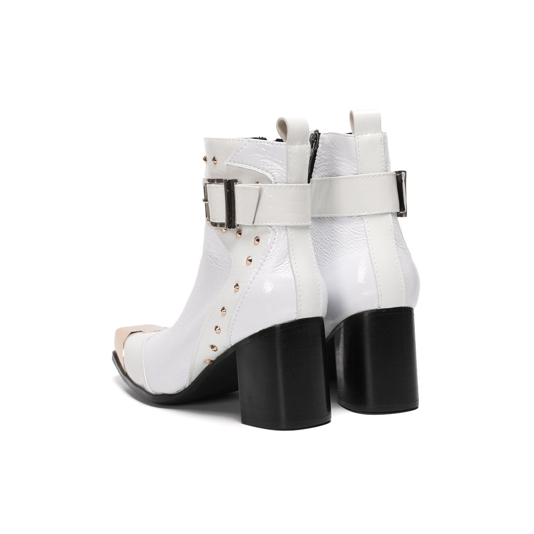 Pair of Dolashoes white patent leather ankle boots with gold metal square toe, studded buckle strap, and black block heel.