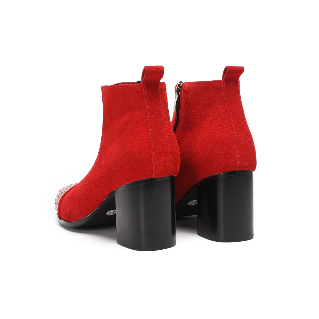 A pair of vibrant red suede ankle boots with silver rhinestones on the pointed toe and a black block heel.