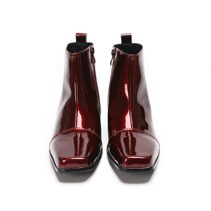 A pair of shiny burgundy patent leather ankle boots with a square toe and block heel, featuring a side zipper closure.