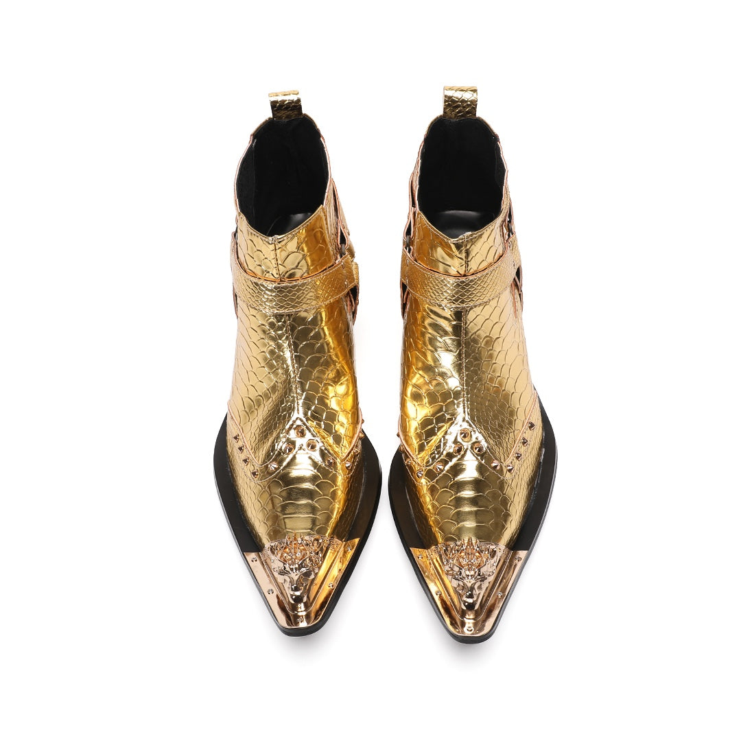 A pair of shiny gold snake skin textured ankle boots with a pointed metal toe cap, studded details, and an ankle strap.