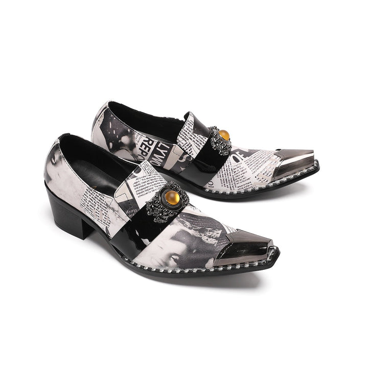 Pair of men's black and white newspaper print slip-on dress shoes with pointed silver metal toe caps and decorative buckles.