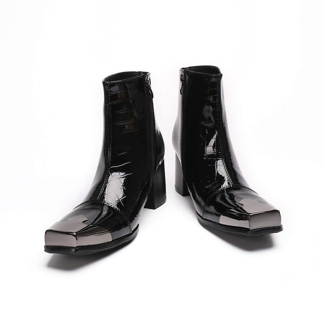 Pair of black patent crocodile embossed ankle boots with square metal toe caps and block heels, side view.