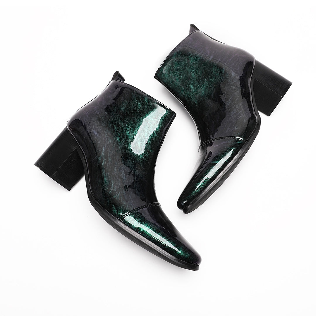 Pair of iridescent dark green patent leather pointed toe ankle boots with block heels and side zippers.