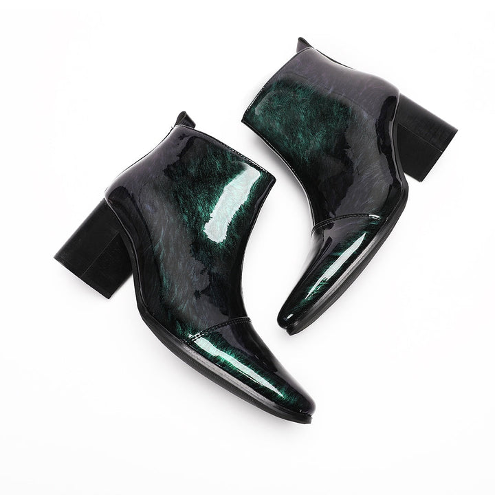 Pair of iridescent dark green patent leather pointed toe ankle boots with block heels and side zippers.