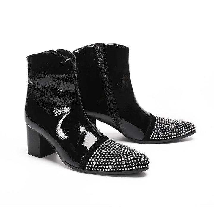 A pair of black patent leather ankle boots with rhinestone-embellished pointed toes and block heels.