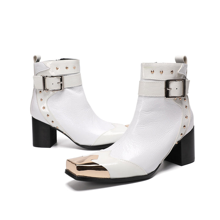 Pair of Dolashoes white patent leather ankle boots with gold metal square toe, studded buckle strap, and black block heel.