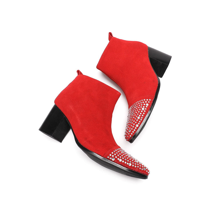 A pair of vibrant red suede ankle boots with silver rhinestones on the pointed toe and a black block heel.