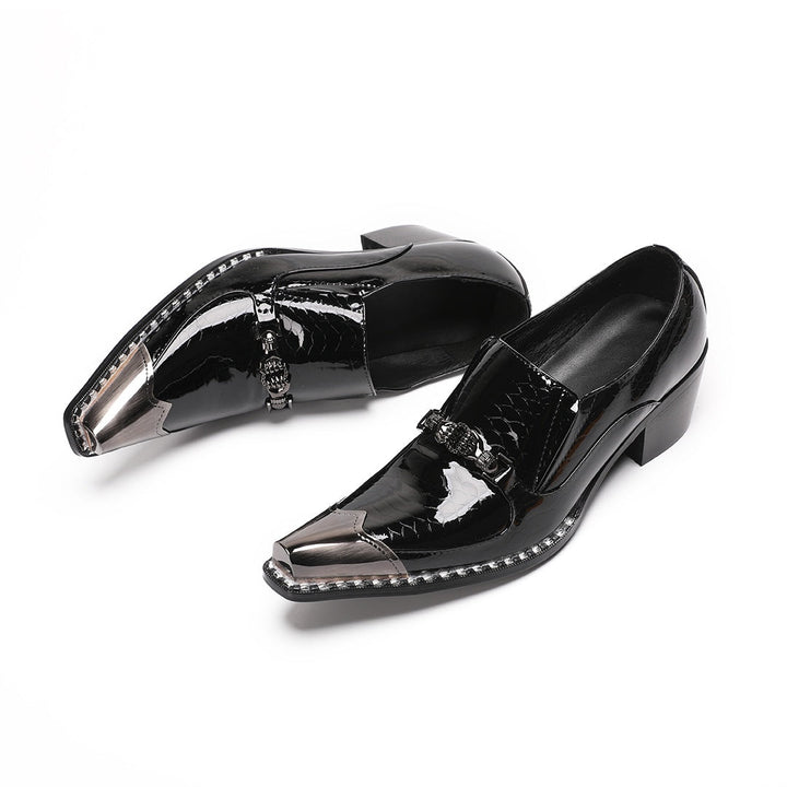 Pair of black patent leather men's loafers with silver metal cap toes and decorative buckles.