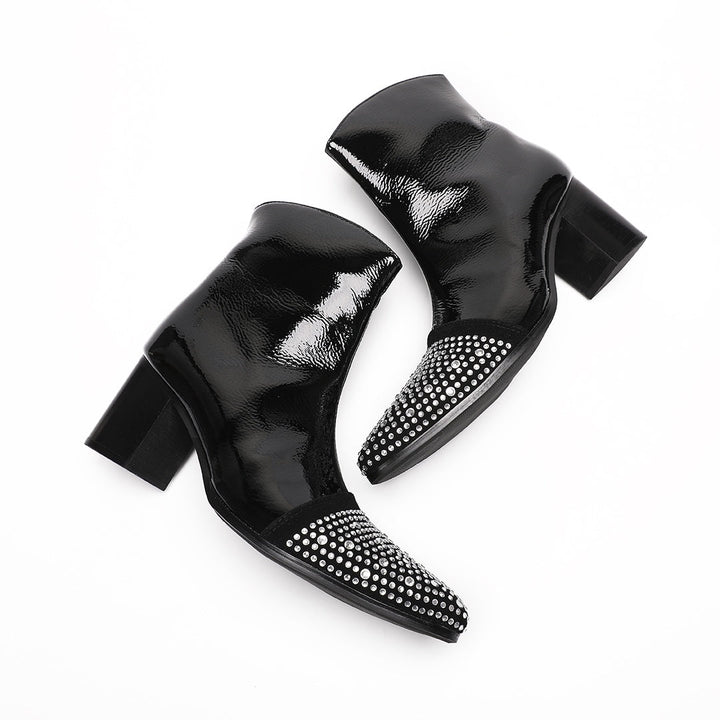 A pair of black patent leather ankle boots with rhinestone-embellished pointed toes and block heels.