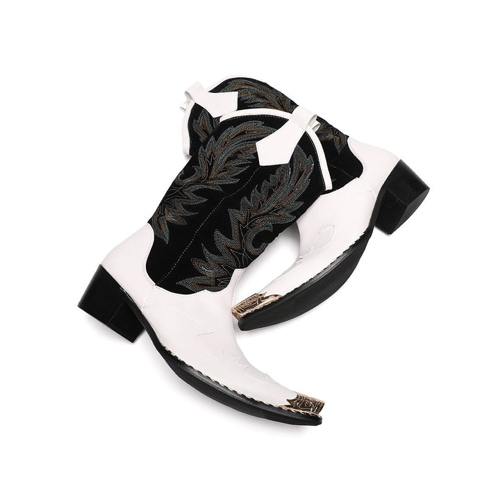 Pair of white and black embroidered cowboy boots with a gold metal tip on a white background.