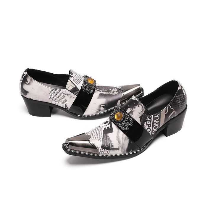 Pair of men's black and white newspaper print slip-on dress shoes with pointed silver metal toe caps and decorative buckles.