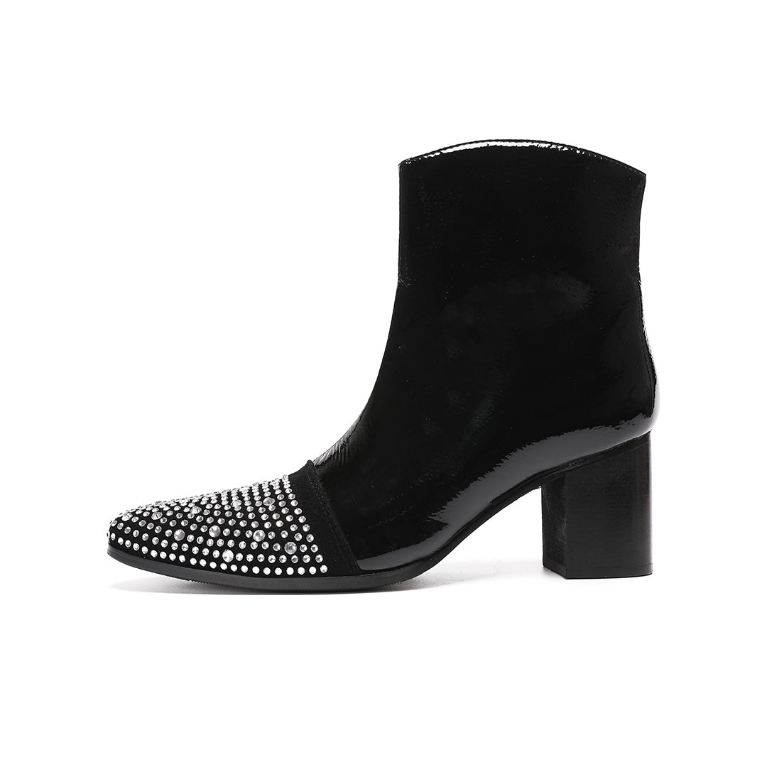 A pair of black patent leather ankle boots with rhinestone-embellished pointed toes and block heels.