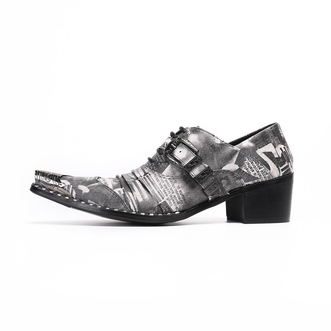Pair of men's high heel derby shoes with a black and white newspaper print, pointed metal toe caps, and buckle details, shown