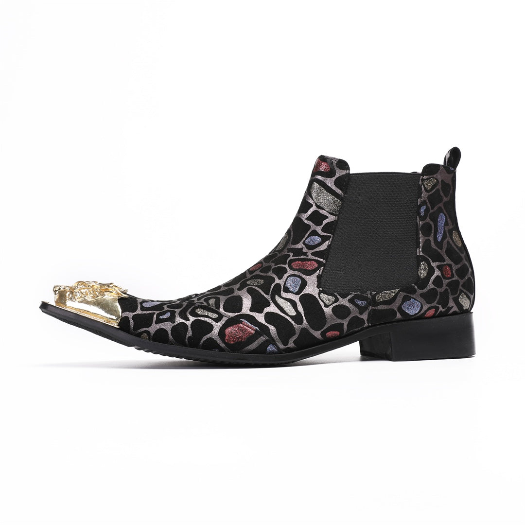 Pair of men's black Chelsea boots with a metallic leopard print pattern and ornate gold metal toe caps, shown on a white