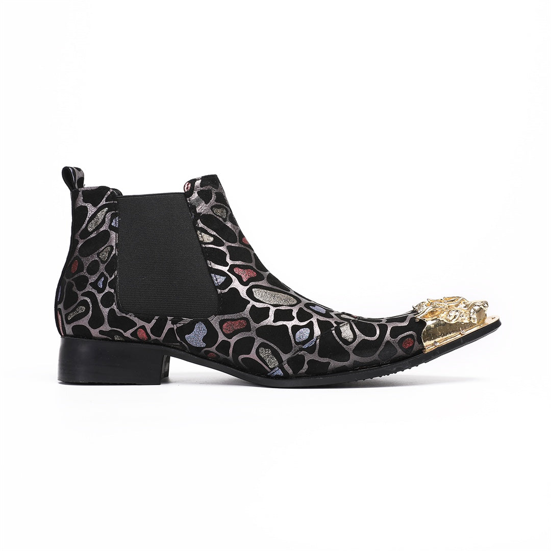 Pair of men's black Chelsea boots with a metallic leopard print pattern and ornate gold metal toe caps, shown on a white