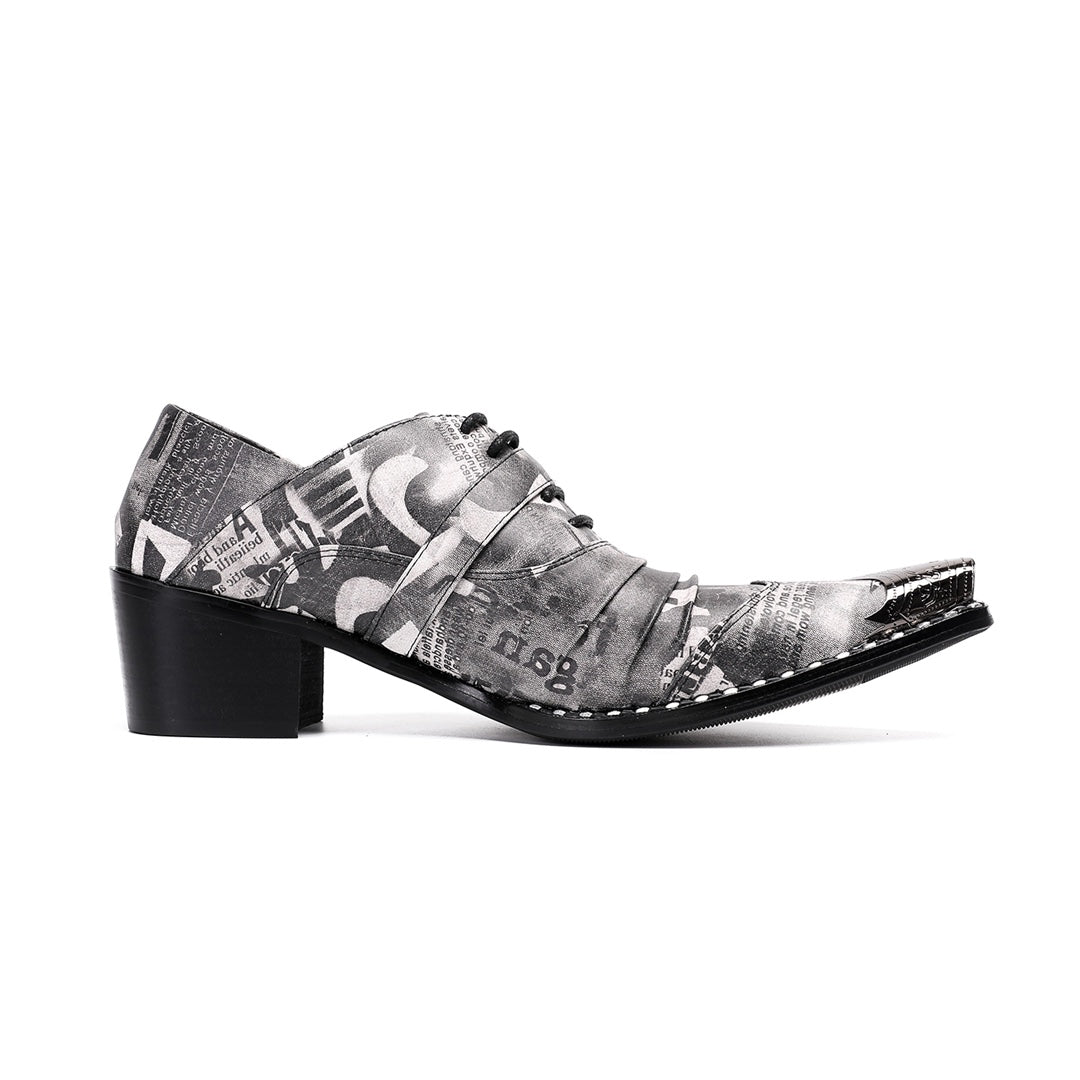 Pair of men's high heel derby shoes with a black and white newspaper print, pointed metal toe caps, and buckle details, shown