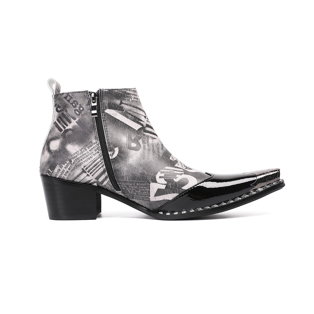 Pair of men's black and white newspaper print ankle boots with a shiny black pointed toe and silver metal tip, side zipper