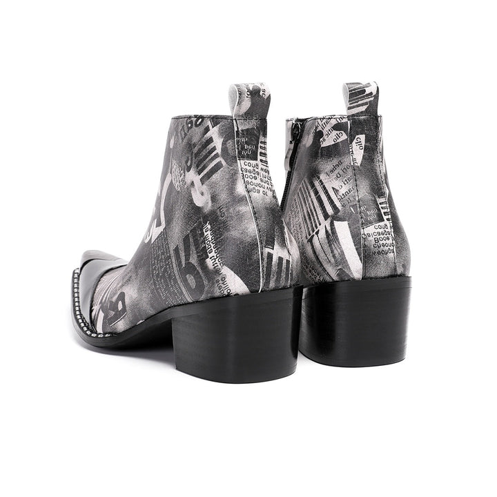 Pair of men's black and white newspaper print ankle boots with a shiny black pointed toe and silver metal tip, side zipper