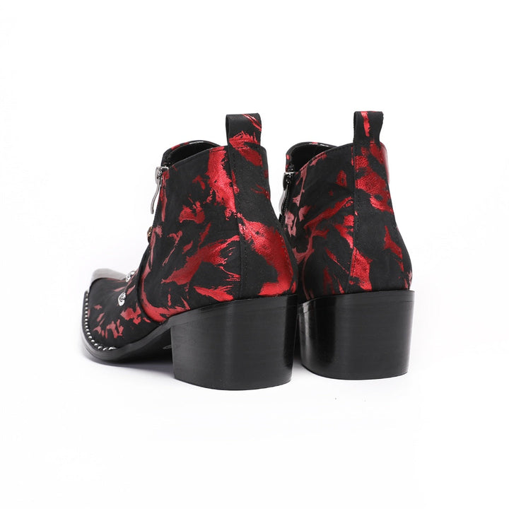 A pair of men's black and red patterned ankle boots with a silver metal pointed toe and a wolf head embellishment on the