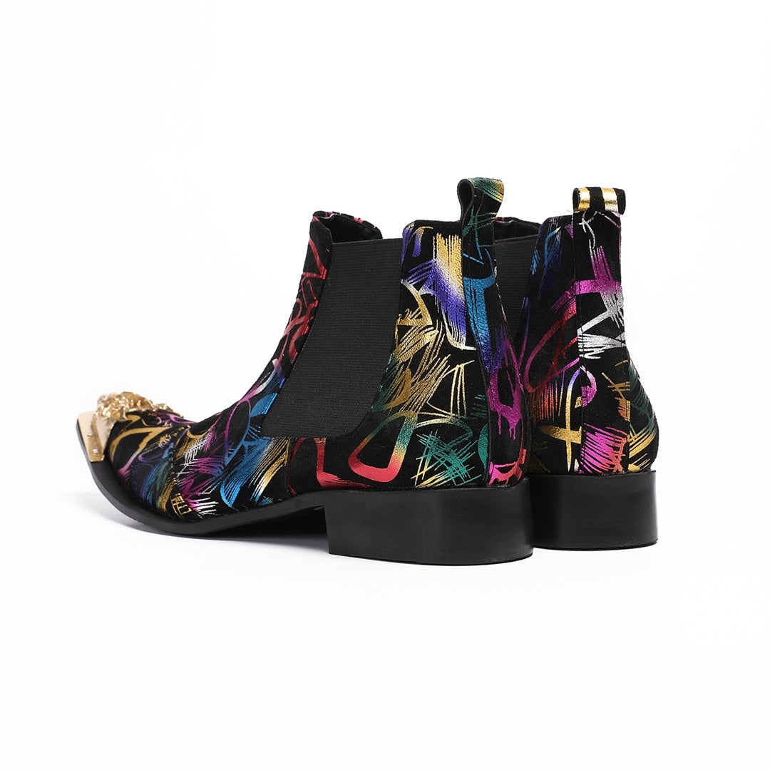 Pair of men's black Chelsea boots with a vibrant multi-color graffiti pattern and a gold metal pointed toe cap, shown from