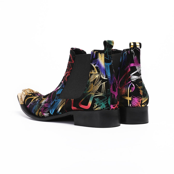 Pair of men's black Chelsea boots with a vibrant multi-color graffiti pattern and a gold metal pointed toe cap, shown from