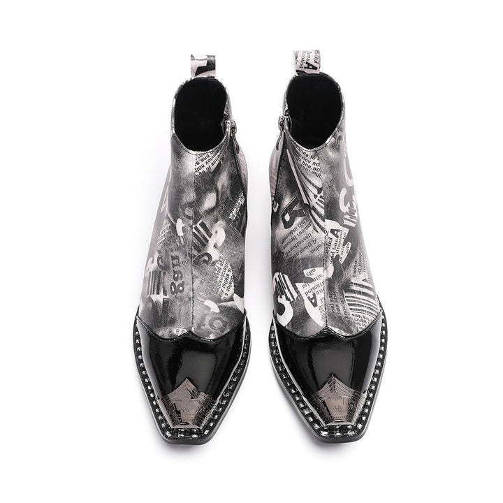Pair of men's black and white newspaper print ankle boots with a shiny black pointed toe and silver metal tip, side zipper