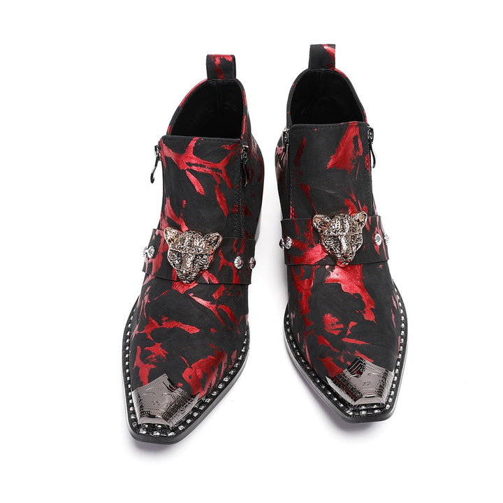 A pair of men's black and red patterned ankle boots with a silver metal pointed toe and a wolf head embellishment on the