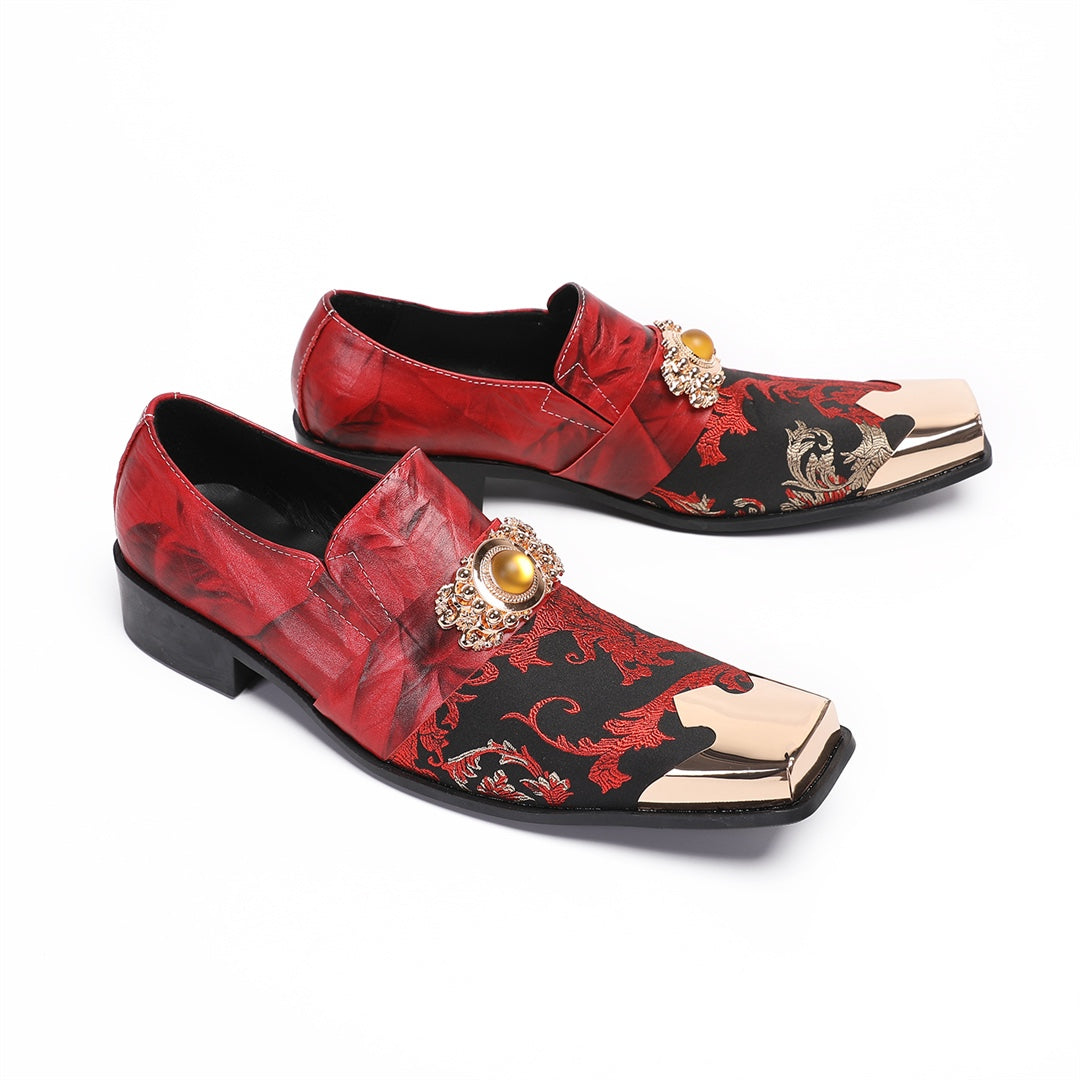 Pair of men's red and black floral slip-on loafers with gold metal square toe and decorative buckle.
