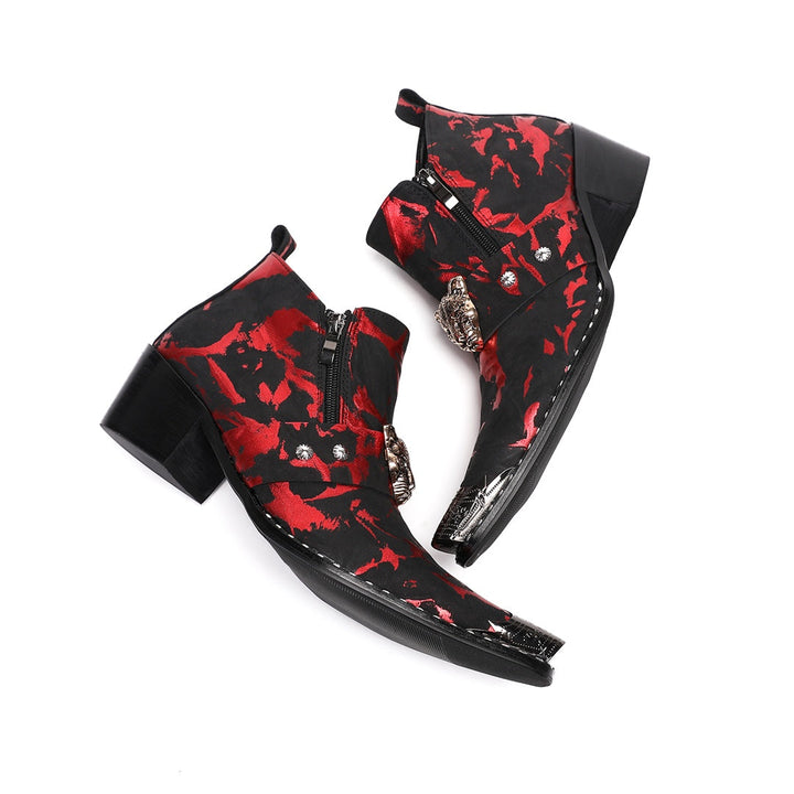 A pair of men's black and red patterned ankle boots with a silver metal pointed toe and a wolf head embellishment on the