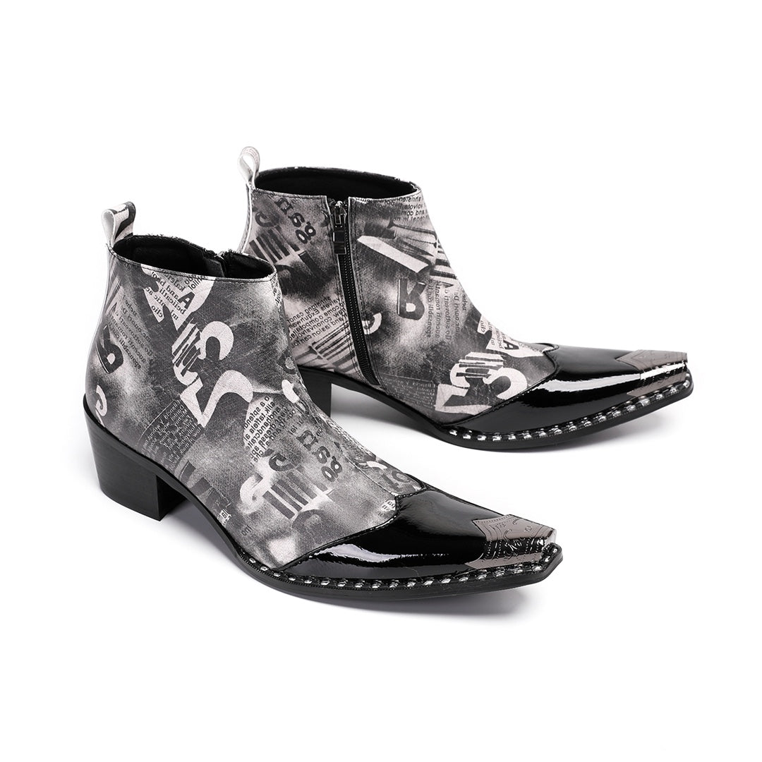 Pair of men's black and white newspaper print ankle boots with a shiny black pointed toe and silver metal tip, side zipper